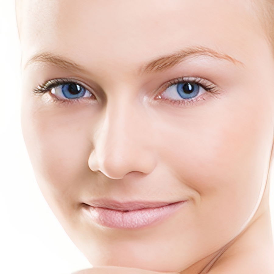 Smiling person with clear skin and blue eyes.